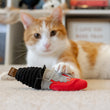 Load image into Gallery viewer, P.L.A.Y. Feline Frenzy Killer Cat Deadly Duo Toy Set - dagger toy in front of ginger cat with claws dug into it
