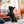 Load image into Gallery viewer, P.L.A.Y. Snack Attack Collection - Lollipup Toy being dangled above a little black dog by dog mom with smiles on both of thier faces in a living room

