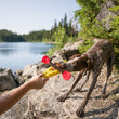 Load image into Gallery viewer, P.L.A.Y. Camp Corbin K9 Kayak Toy in dog's mouth playing tug with human shore with lake to the left