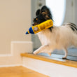 Load image into Gallery viewer, P.L.A.Y. Totally Touristy Big Ben Toy - XS size toy in mouth of little white fluffy dog running down the stairs from the entryway
