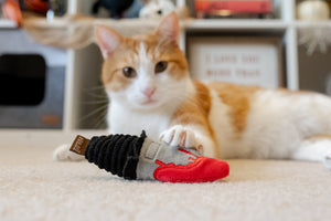 P.L.A.Y. Feline Frenzy Killer Cat Deadly Duo Toy Set - dagger toy in front of ginger cat with claws dug into it