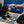 Load image into Gallery viewer, P.L.A.Y. Big Five of Africa Collection - Rhino Toy in dog&#39;s mouth playing tug with human on a blue rug
