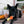 Load image into Gallery viewer, P.L.A.Y. Howling Haunts Collection - Canine Corn Toy with beautiful black dog chewing on it while laying on the porch
