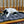 Load image into Gallery viewer, Cat lying on a P.L.A.Y. Feline Frenzy Cat Nap Pad in front of wooden stairs
