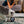 Load image into Gallery viewer, P.L.A.Y. Hollywoof Cinema Momo&#39;s Movie Reel Toy - scruffy gray and white dog playing with toy on rug in living room
