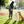 Load image into Gallery viewer, Landscape Series Deluxe Training Pouch in Sunrise  - human wearing in park reaching into pouch for treats to give her two cute waiting pups
