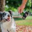 Load image into Gallery viewer, Proper Pup Poop Bag Dispensers from P.L.A.Y. - dog looking at Army Green dispenser with human tugging at bags
